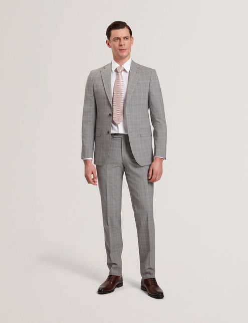 A male model wearing a light grey suit jacket with a notched lapel, single-breasted two-button fastening, and flap front pockets. He is also wearing a white shirt and a patterned tie.